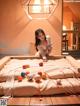 A woman sitting on top of a bed covered in balls.