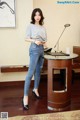 A woman standing in front of a desk in a room.