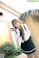 A woman in a school uniform posing for a picture.