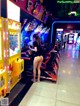 A woman standing in front of a row of arcade machines.