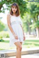 A woman in a white dress posing for a picture.